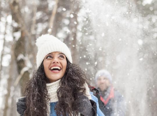 Cheerful young woman having fun in the snow forest stock photo